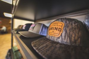 Backwoods Grind hats on the shelf in the shop.